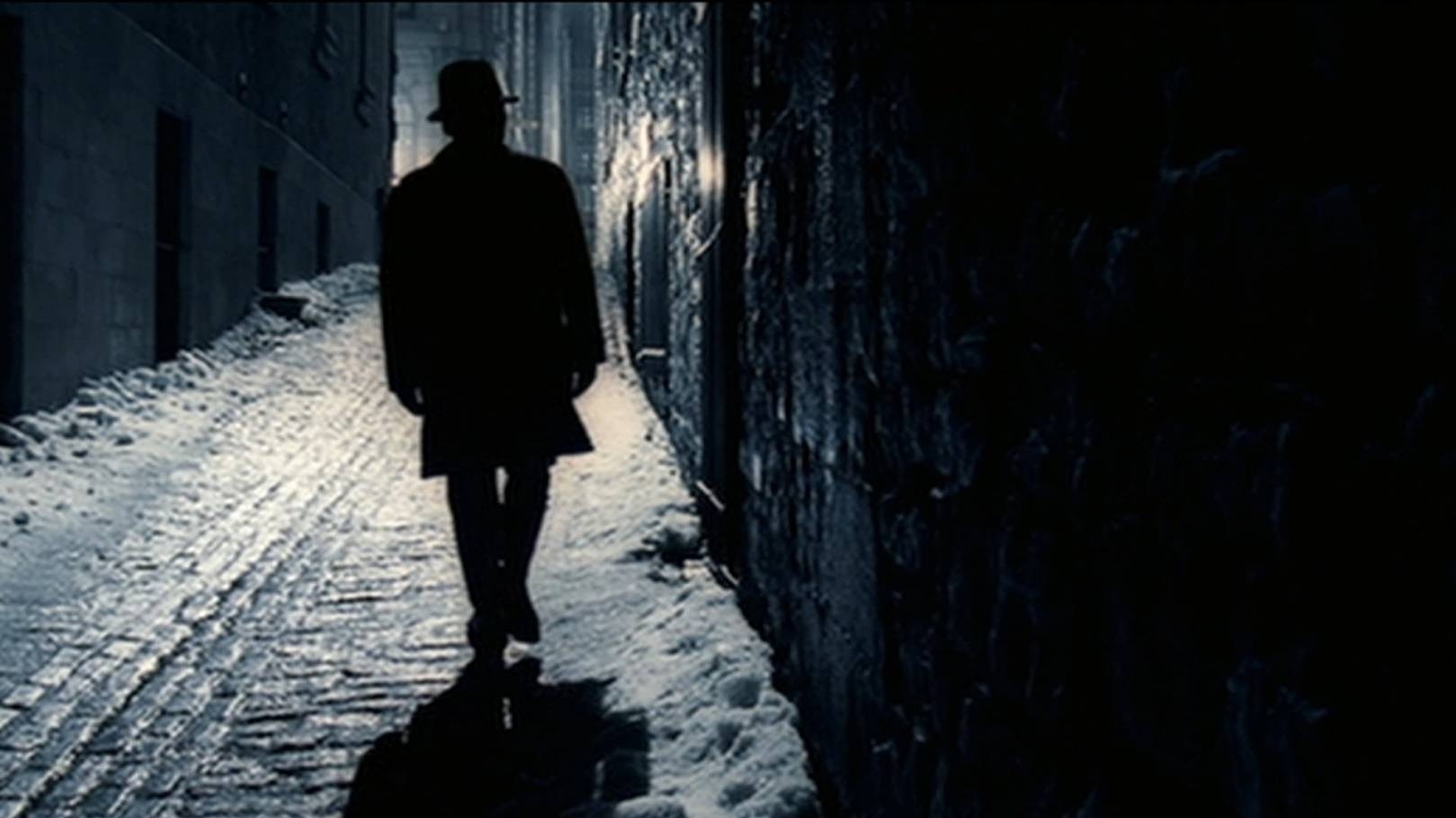 Il protagonista Chuck Barris (Sam Rockwell) cammina di notte in una strada illuminata